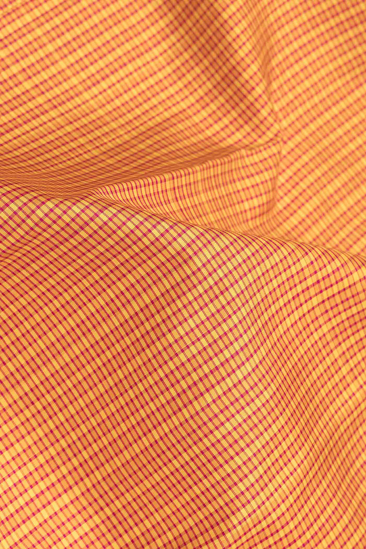 Close up of Mustard Dual Tone Kanchipuram Saree with Checked design on the body and Zari Border.  displaying folds