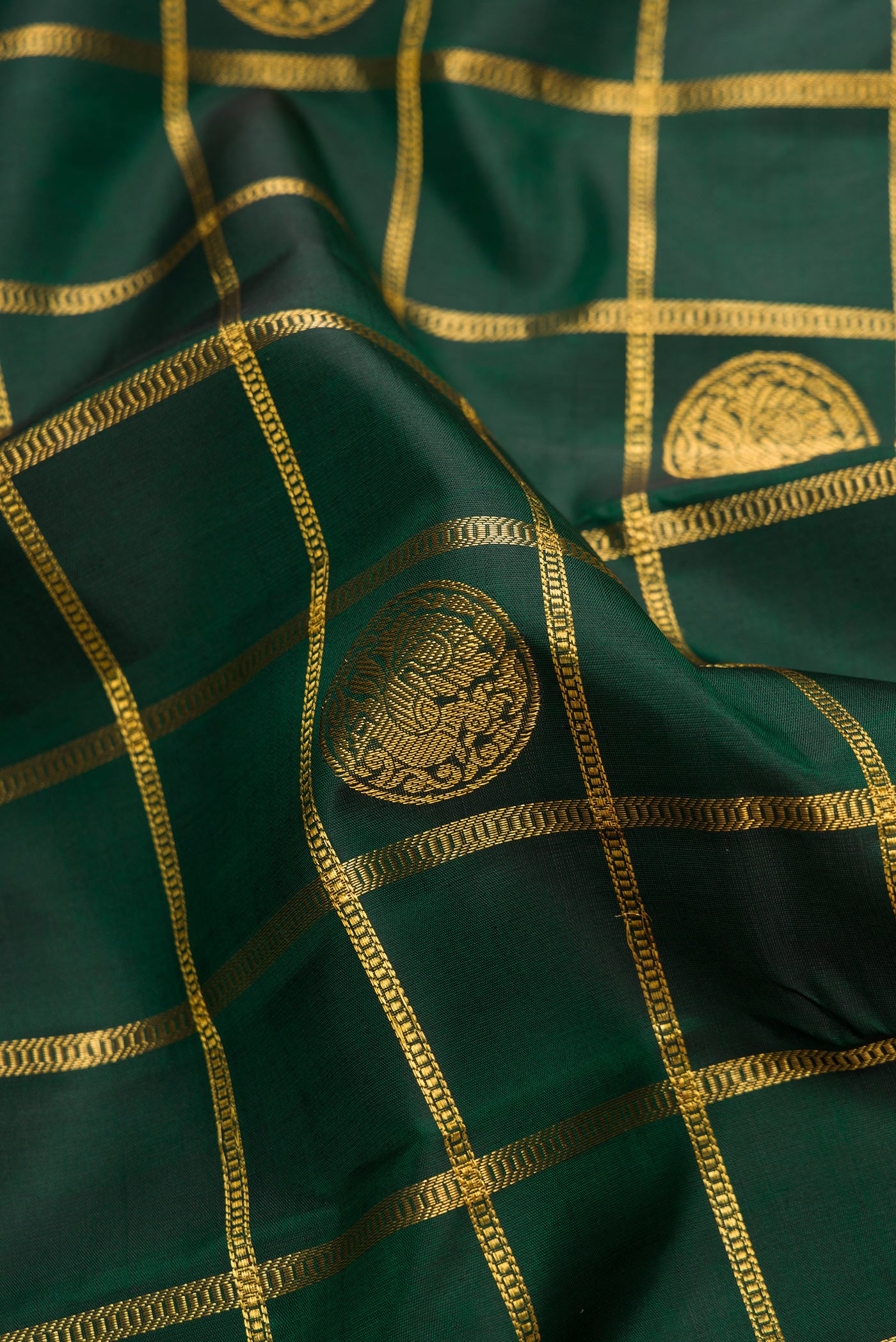 Close up of Pure Silk Pure Zari Bottle Green Dual Tone Kanjivaram Saree with Checked design on the body and Zari Border.  displaying folds