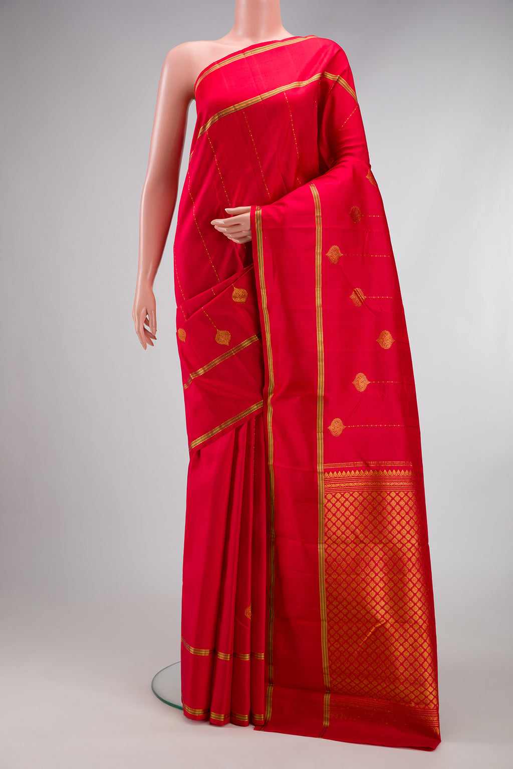 Red Kanjivaram Silk Saree with Stripes on the body and Zari Border.  displayed on a mannequin
