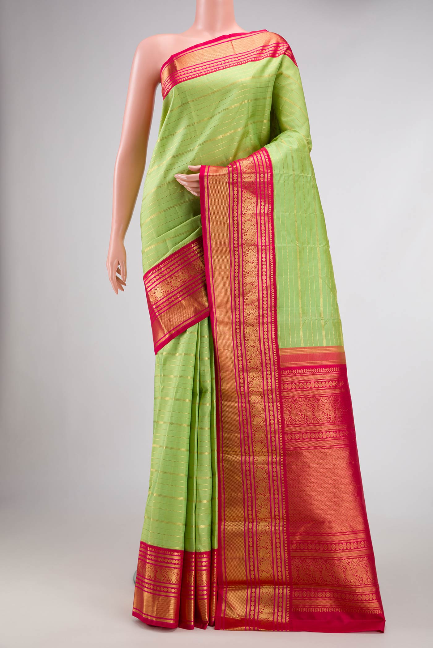 Parrot Green Dual Tone Kanchipuram Silk Saree with Stripes on the body and Zari Border.  displayed on a mannequin