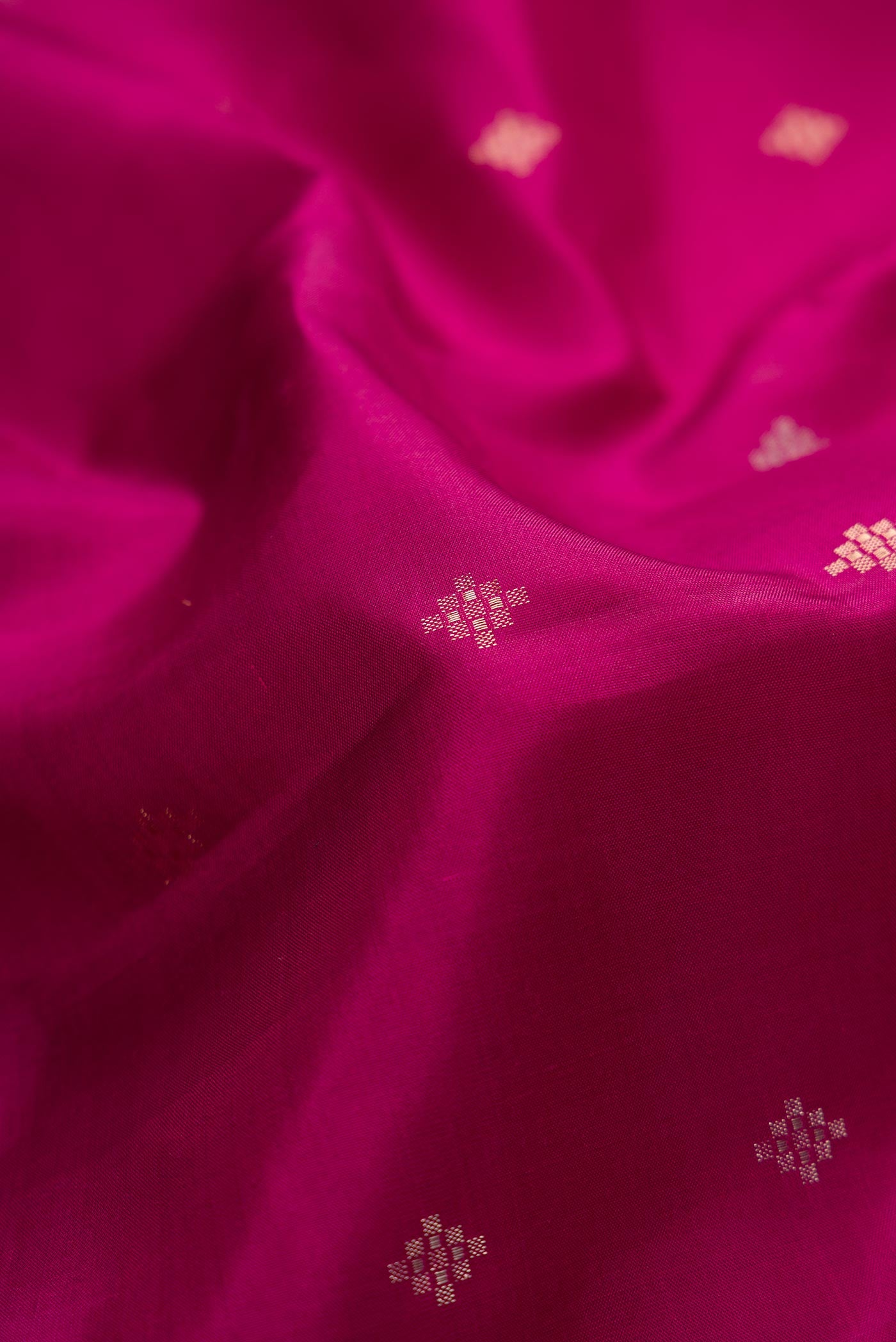 Close up of Magenta Dual Tone Soft Silk Saree with Zari Butta on the body and Zari Border.  displaying folds