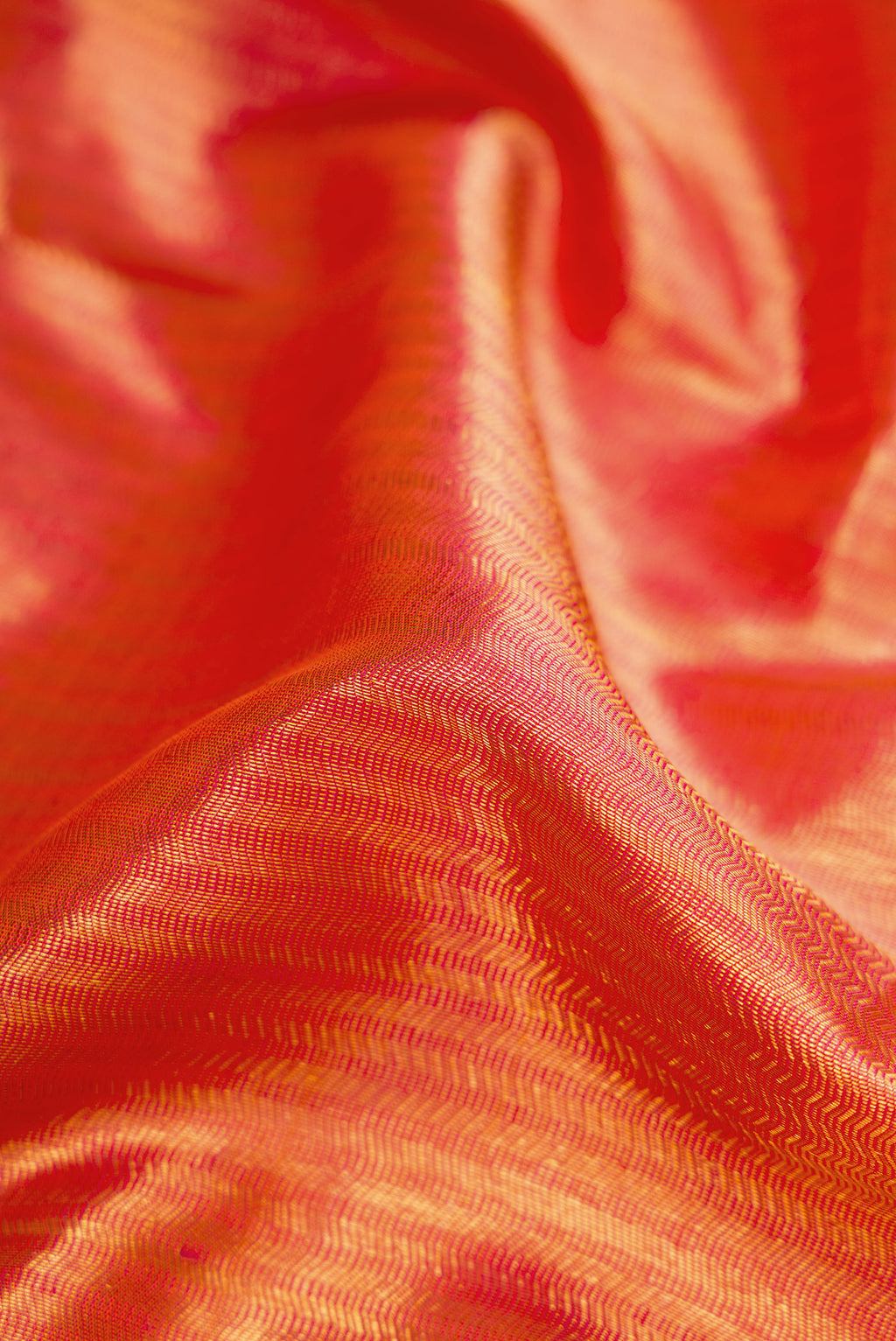 Close up of Orange Kanchipuram Silk Saree with Zari Brocade on the body and Zari Border.  displaying folds