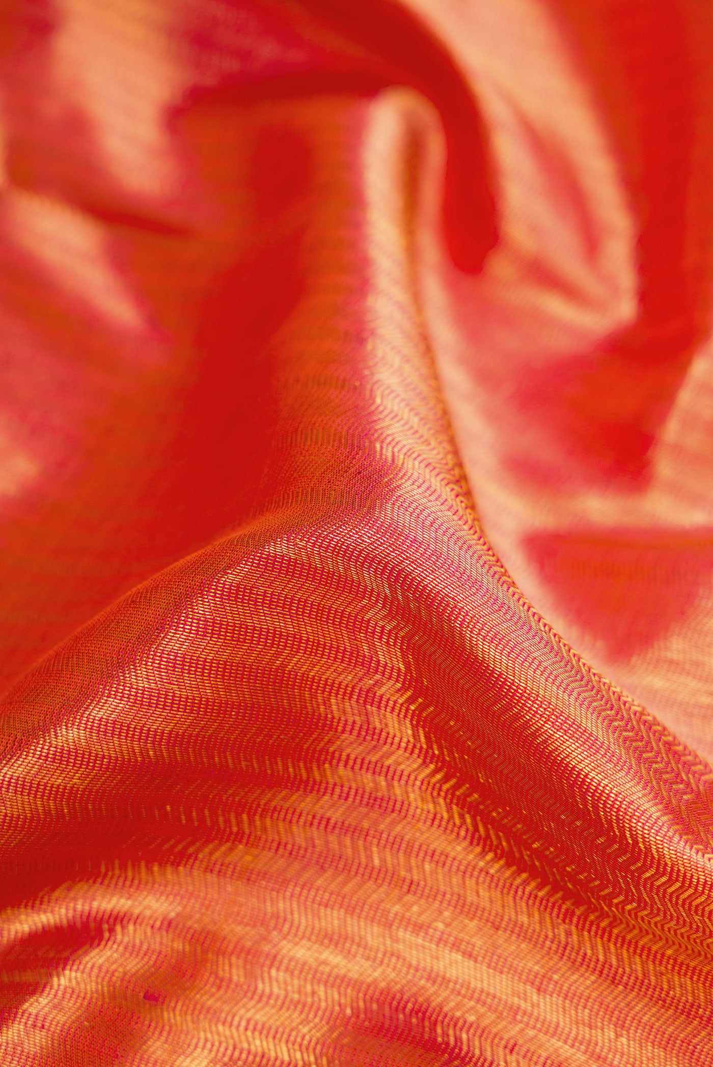 Close up of Orange Kanchipuram Silk Saree with Zari Brocade on the body and Zari Border.  displaying folds