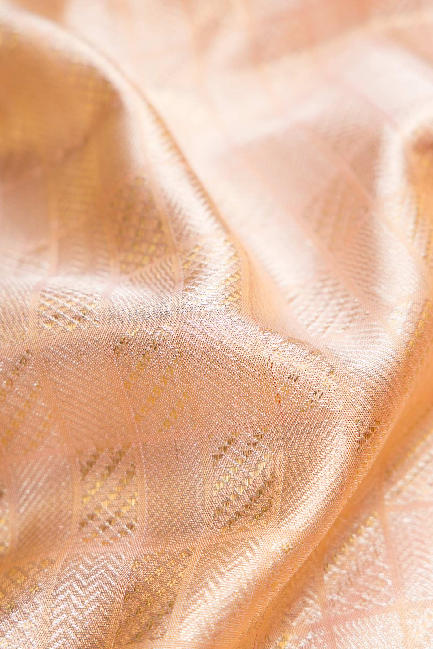 Close up of Rose Gold Dual Tone Kanjivaram Silk Saree with Zari Brocade on the body and Zari Border.  displaying folds