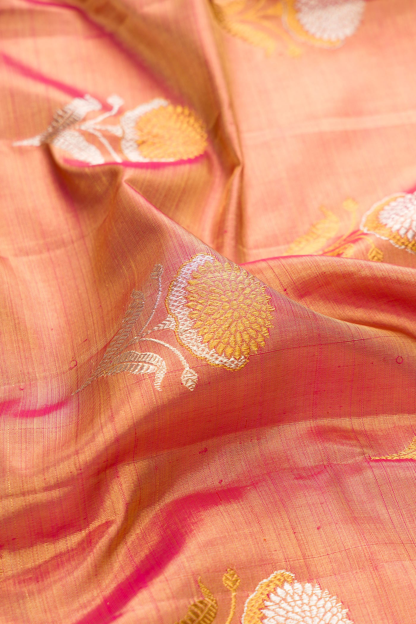 Close up of Rose Gold Dual Tone Kanjivaram Tissue Silk Saree with Zari Brocade on the body and Zari Border.  displaying folds