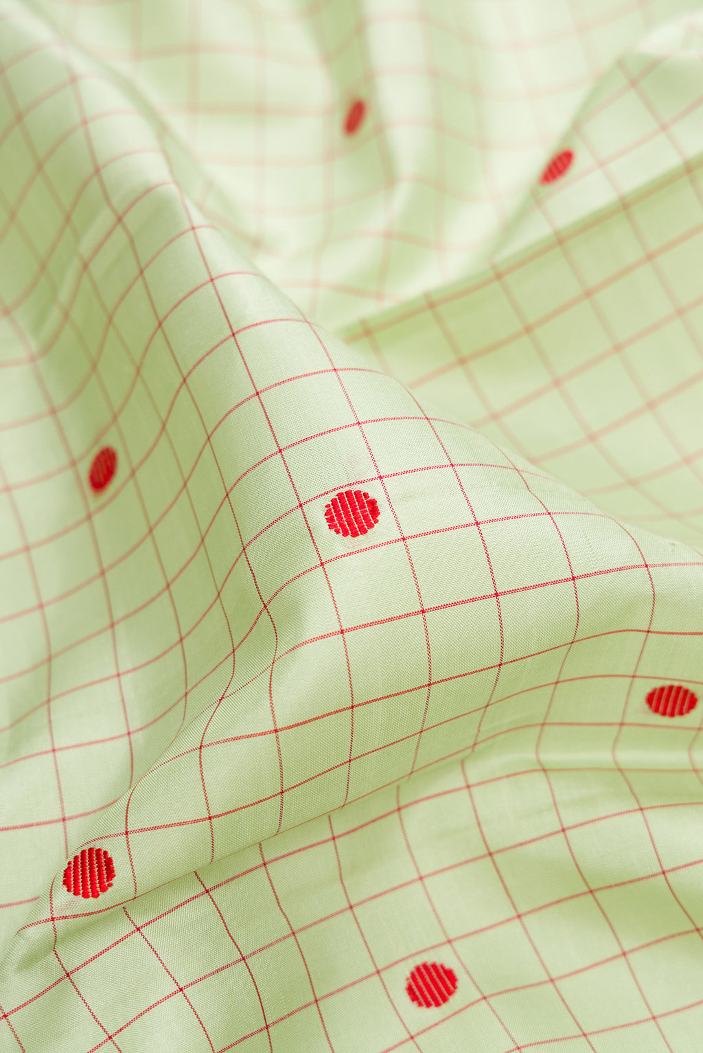 Close up of Pista Green Kanjivaram Silk Saree with Checked design on the body and Thread Border.  displaying folds