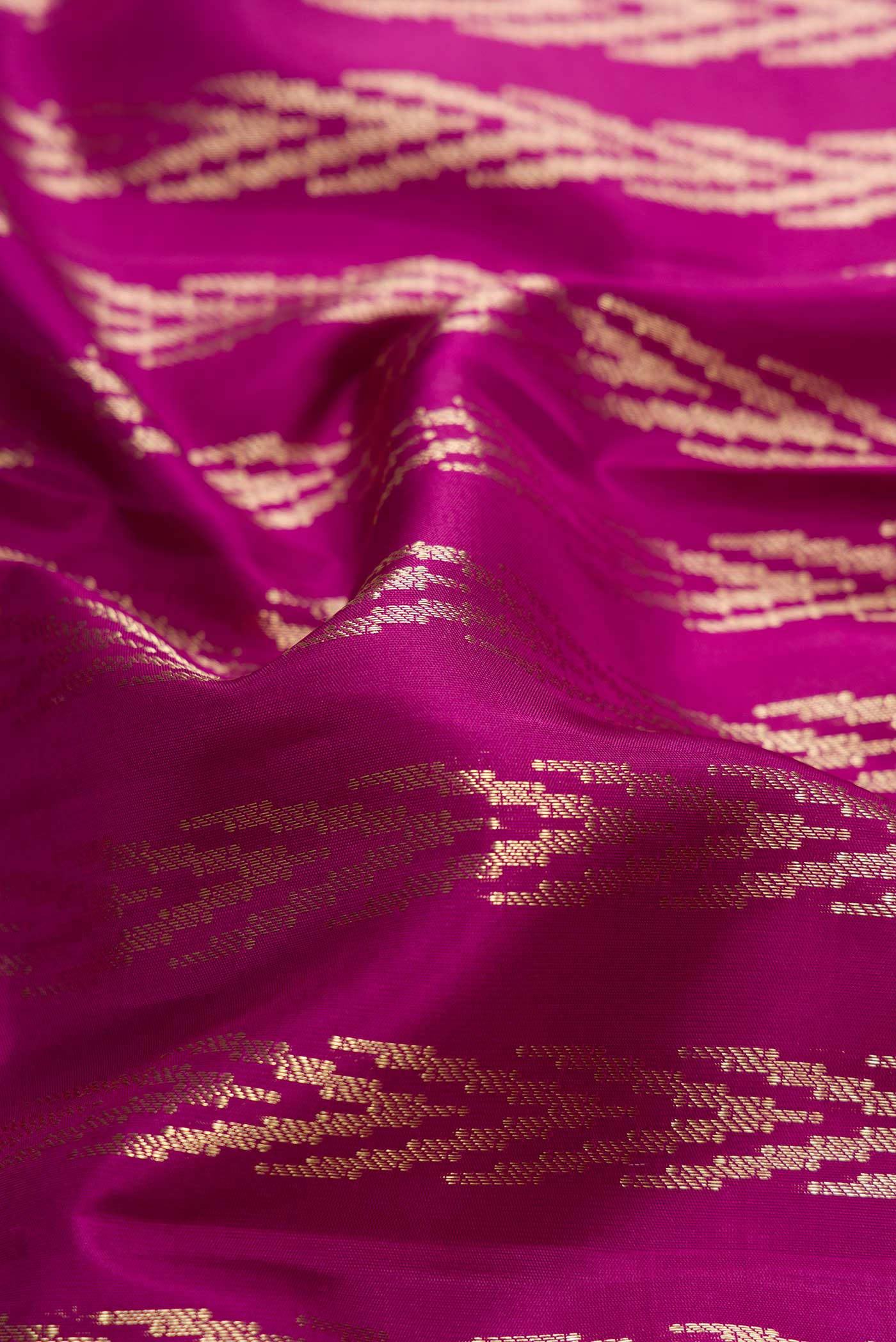 Close up of Magenta Dual Tone Kanjivaram Silk Saree with Zari Brocade on the body and Zari Border.  displaying folds