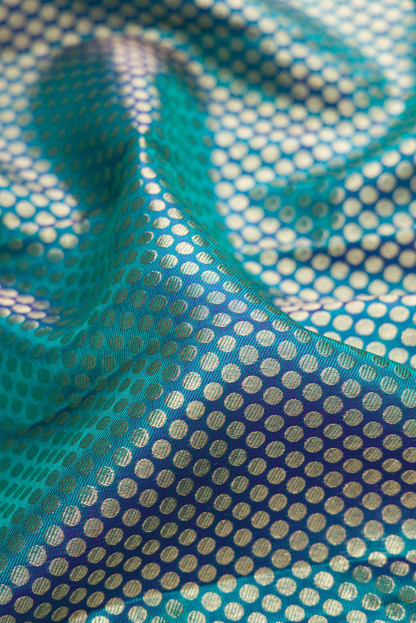 Close up of Peacock Blue Dual Tone Kanjivaram Silk Saree with Zari Brocade on the body and Zari Border.  displaying folds