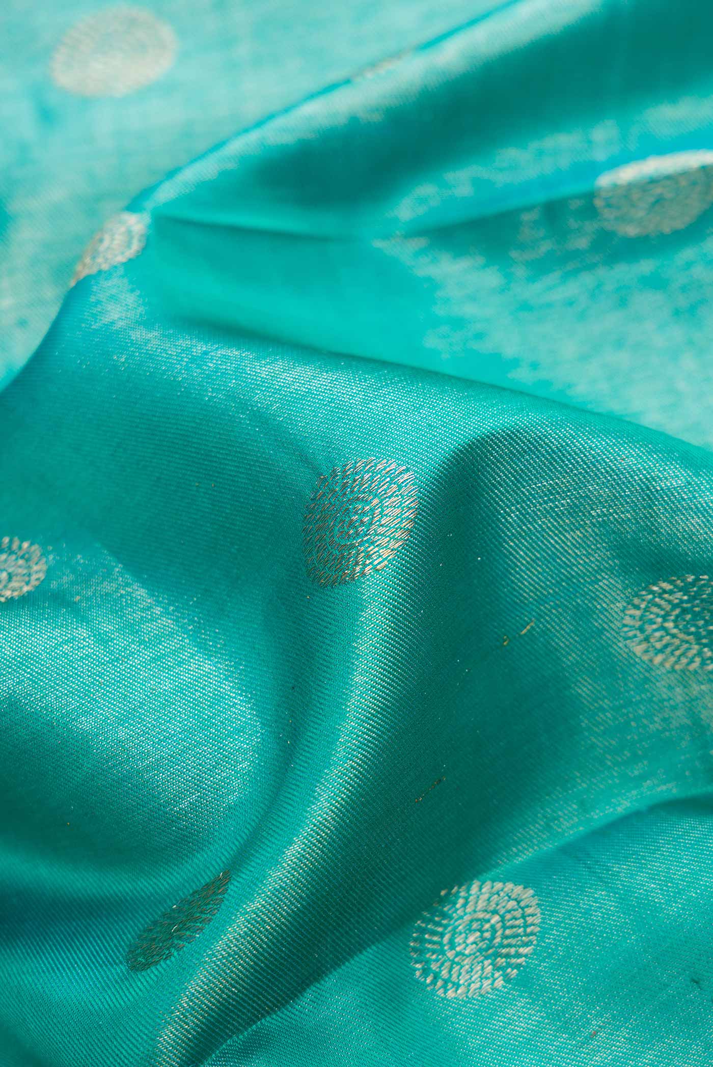 Close up of Peacock Blue Dual Tone Kanjivaram Silk Saree with Zari Brocade on the body and Zari Border.  displaying folds