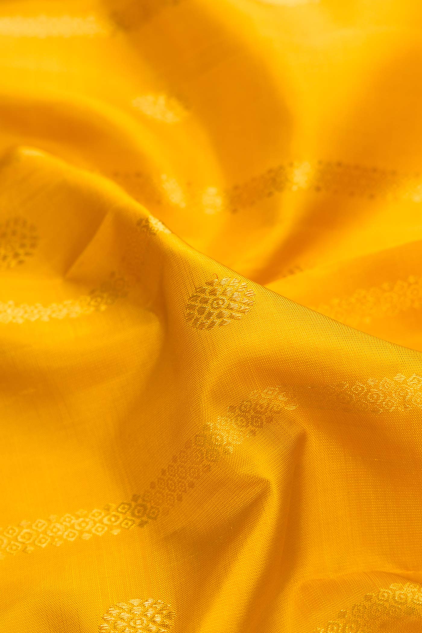 Close up of Mustard Dual Tone Kanchipuram Silk Saree with Stripes on the body and Zari Border.  displaying folds