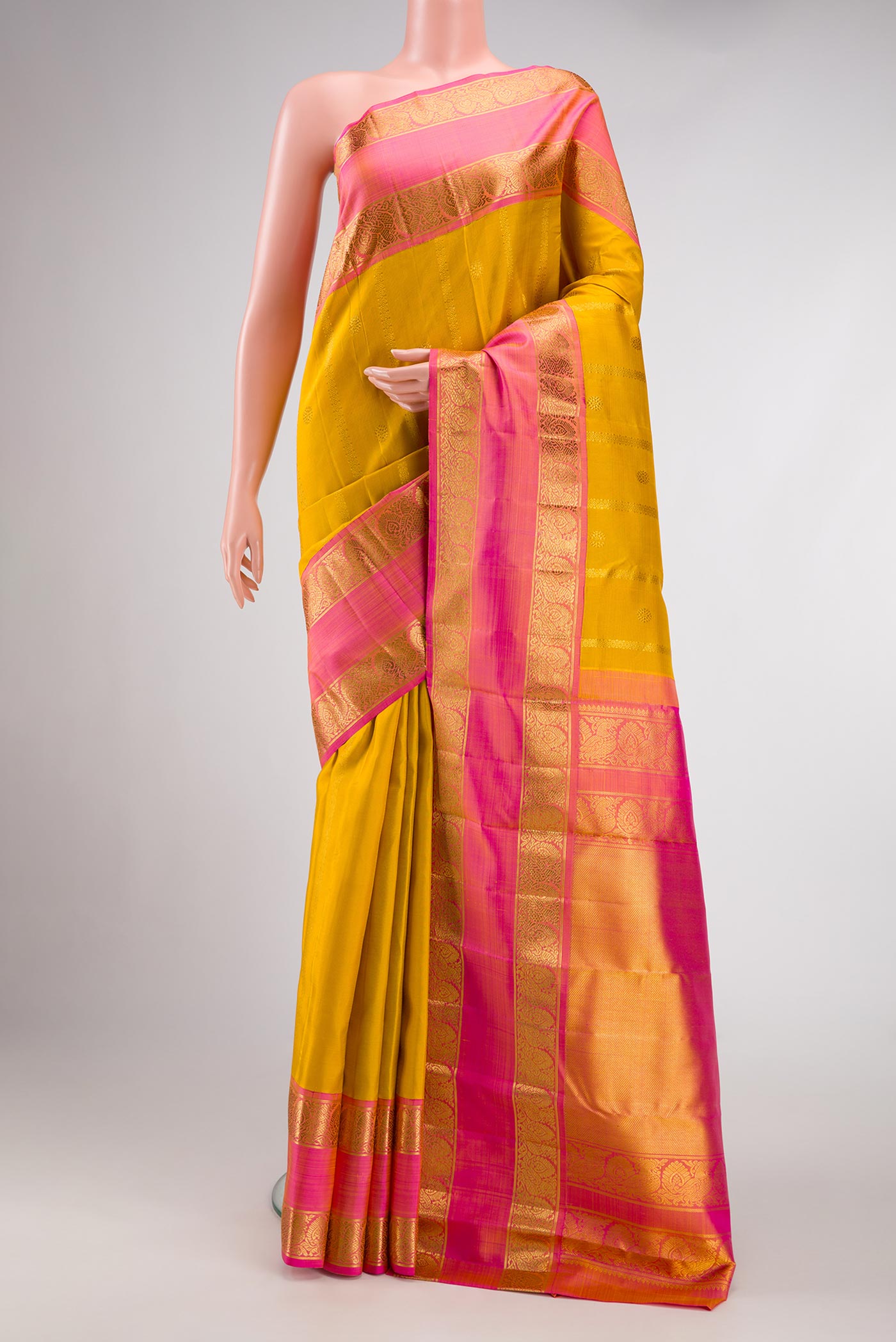 Mustard Dual Tone Kanchipuram Silk Saree with Stripes on the body and Zari Border.  displayed on a mannequin