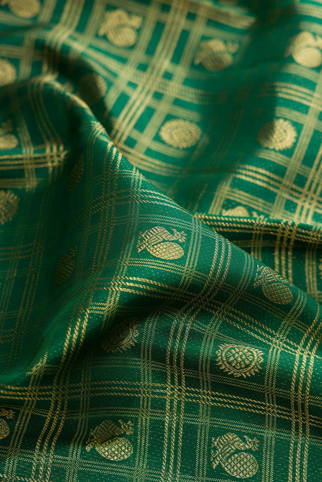 Close up of Pure Silk Bottle Green Kanchipuram Saree with Zari Brocade on the body and Fancy Border.  displaying folds