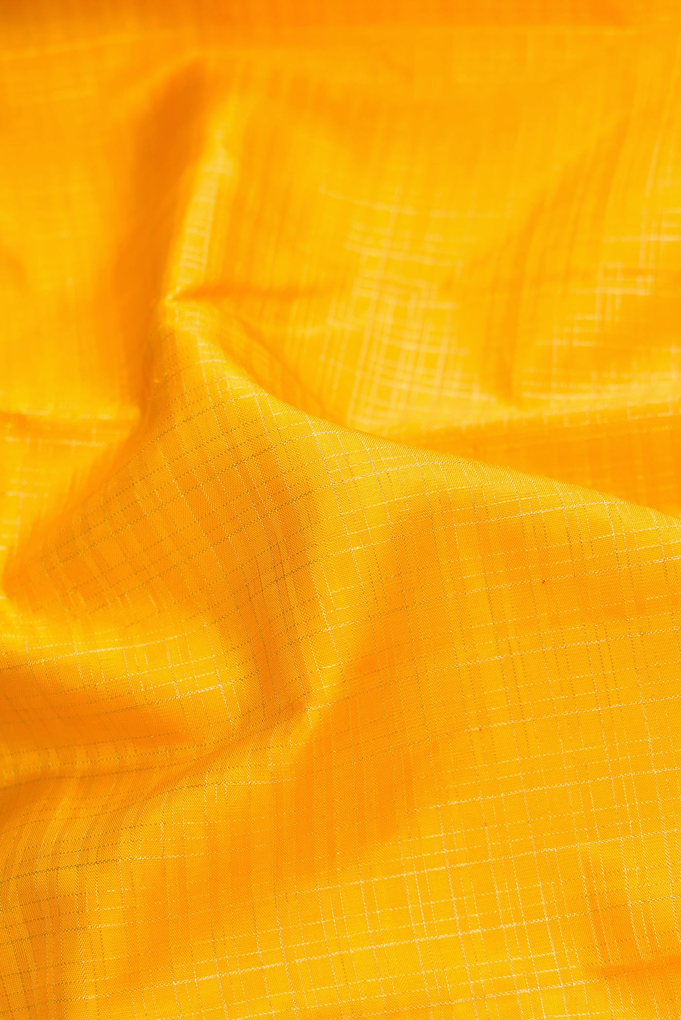 Close up of Yellow Dual Tone Kanchipuram Silk Saree with Checked design on the body and Zari Border.  displaying folds