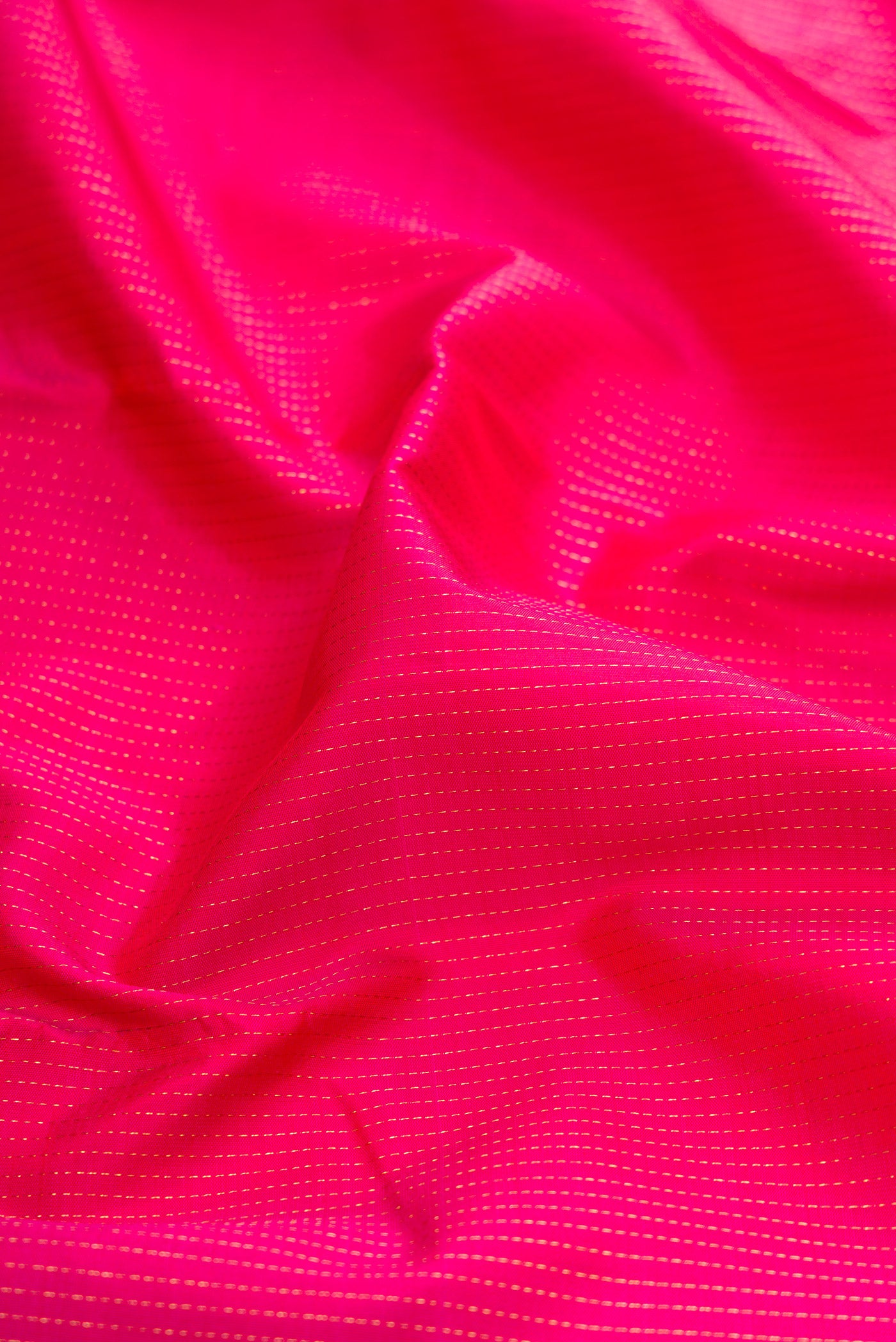 Close up of Dark Pink Kanjivaram Silk Saree with Stripes on the body and Zari Border.  displaying folds
