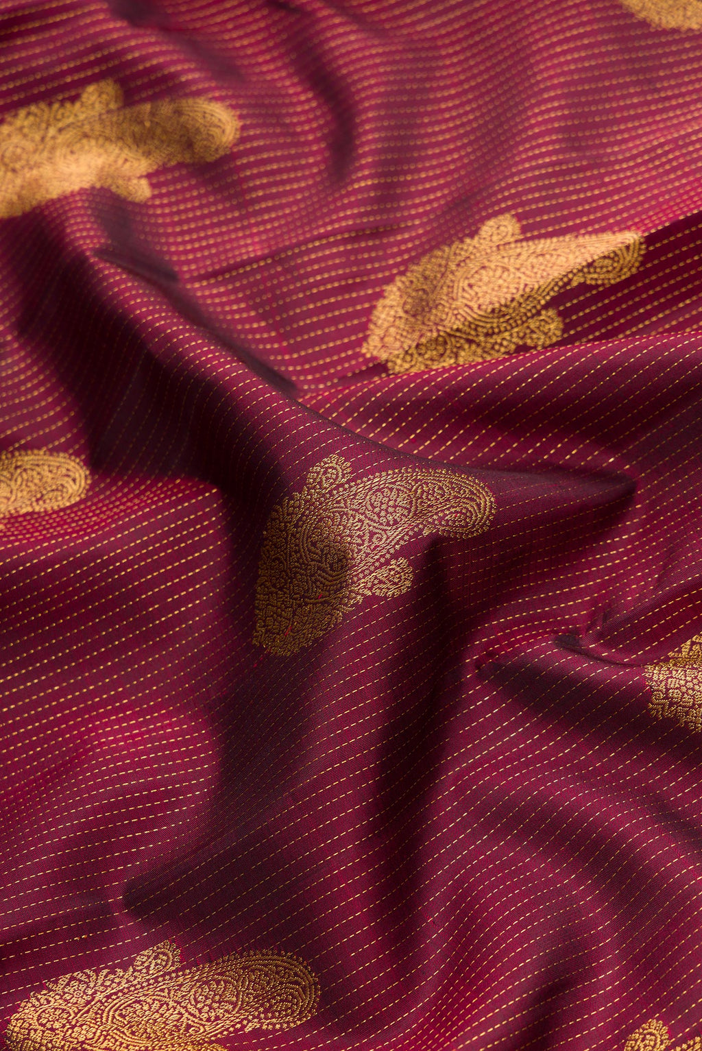 Close up of Pure Silk Pure Zari Maroon Dual Tone Kanjivaram Saree with Stripes on the body and Zari Border.  displaying folds