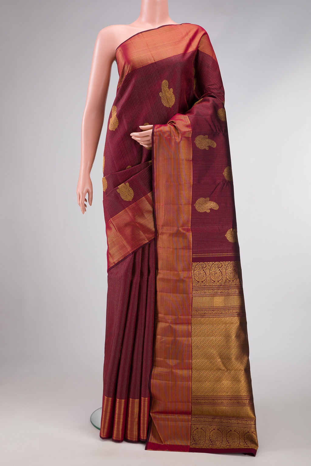 Pure Silk Pure Zari Maroon Dual Tone Kanjivaram Saree with Stripes on the body and Zari Border.  displayed on a mannequin