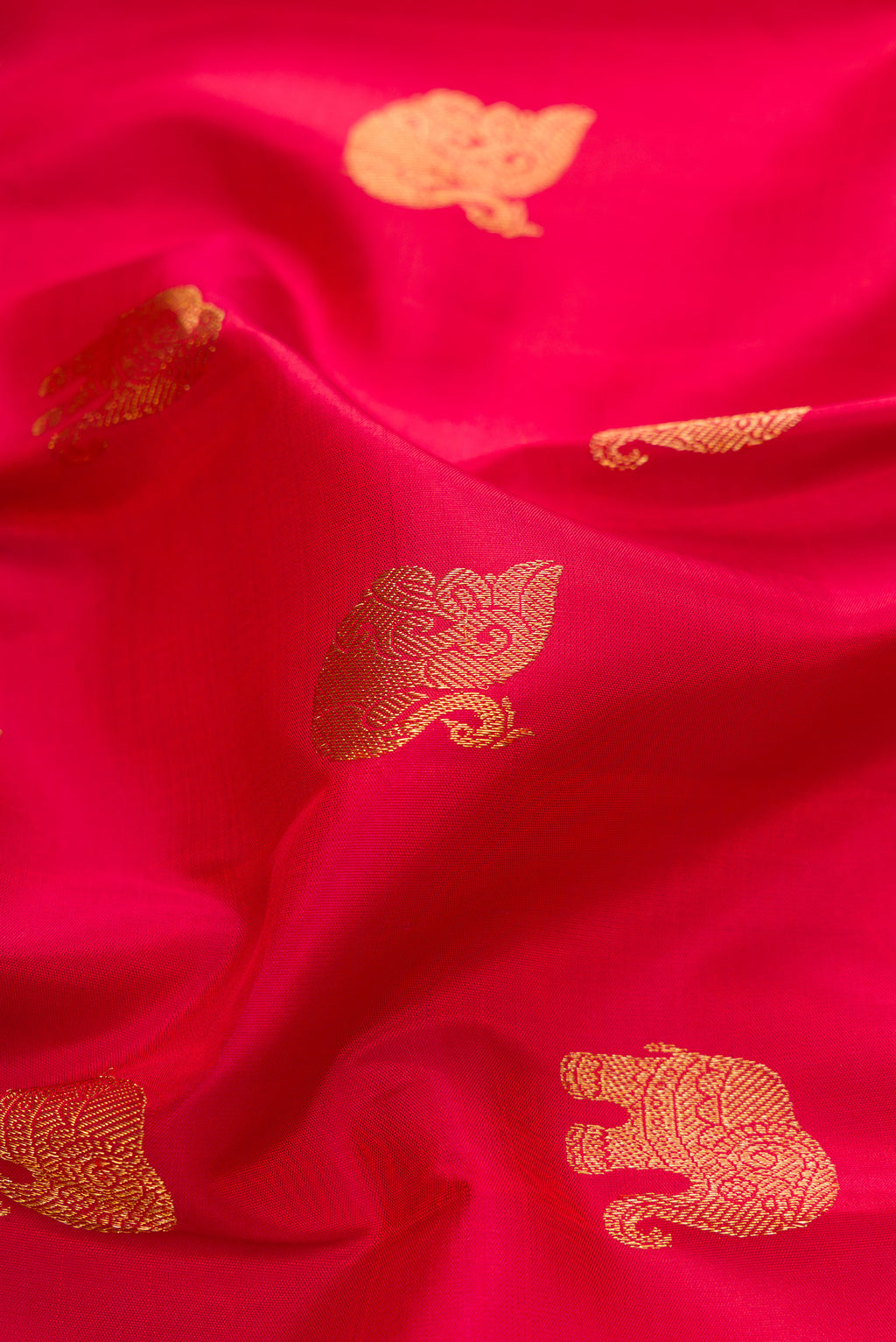Close up of Pure Silk Pure Zari Red Dual Tone Kanjivaram Saree with Zari Butta on the body and Zari Border.  displaying folds