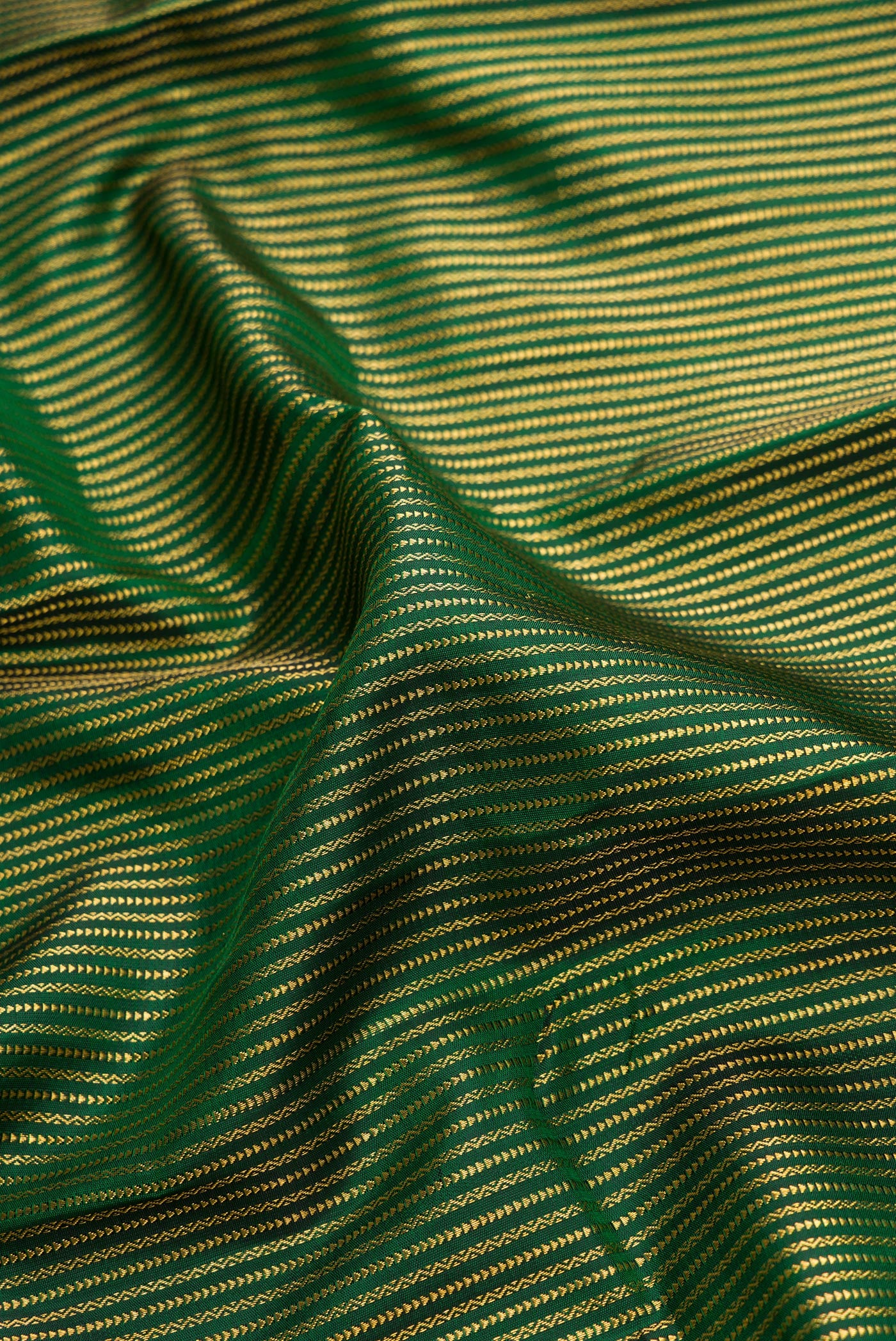 Close up of Pure Silk Pure Zari Bottle Green Dual Tone Kanchipuram Saree with Stripes on the body and Zari Border.  displaying folds