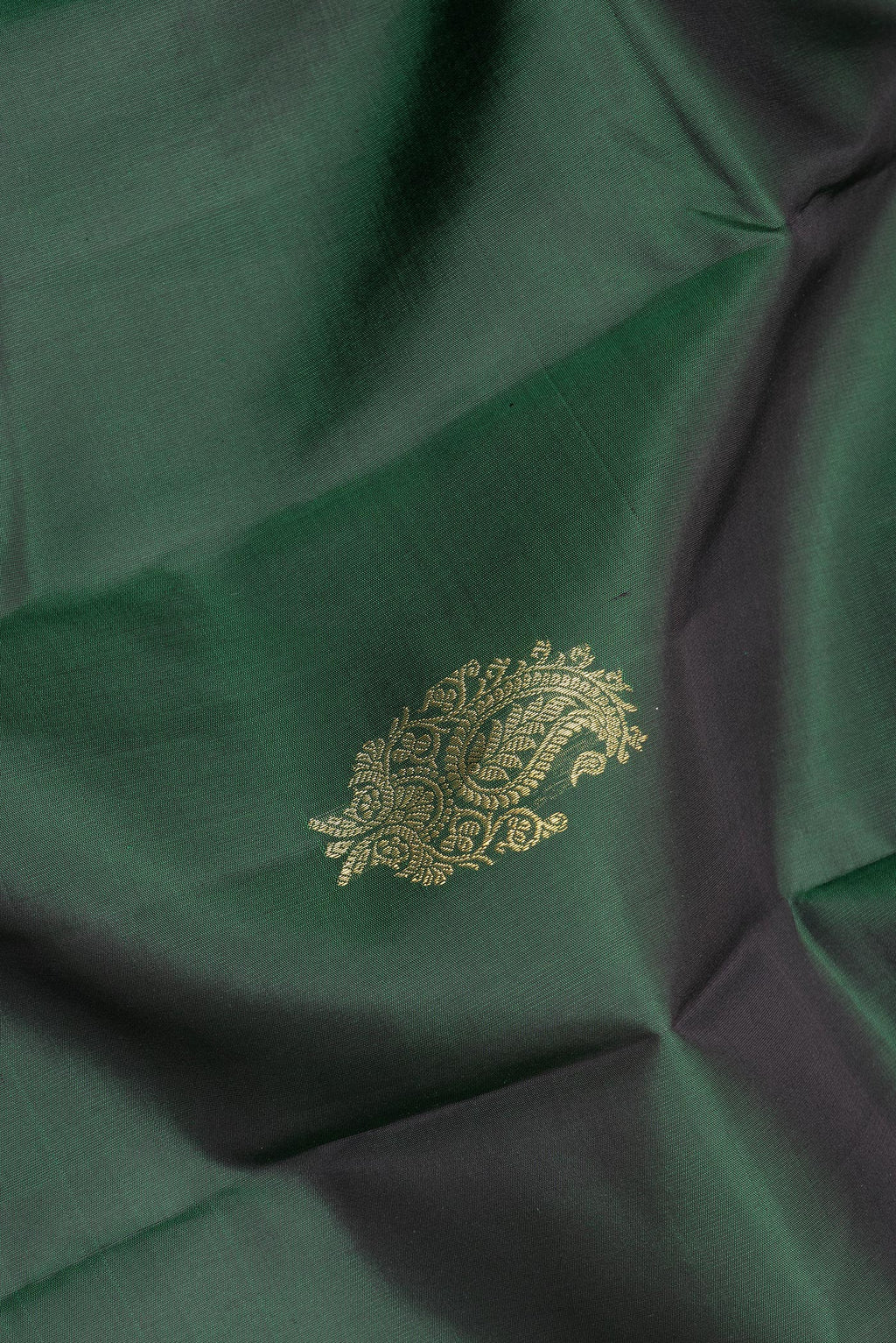 Close up of Pure Silk Bottle Green Dual Tone Kanjivaram Saree with Zari Butta on the body and Fancy Border.  displaying folds