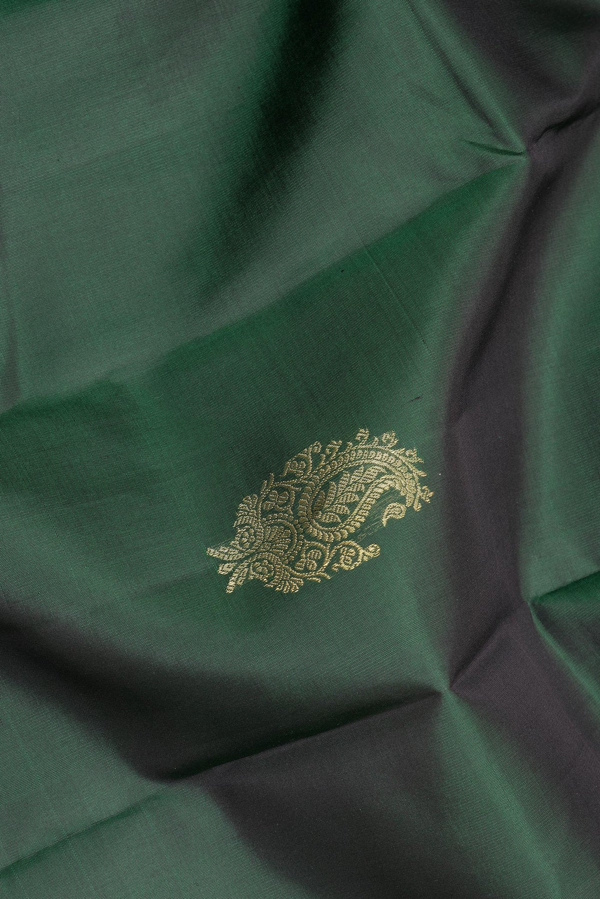 Close up of Pure Silk Bottle Green Dual Tone Kanjivaram Saree with Zari Butta on the body and Fancy Border.  displaying folds
