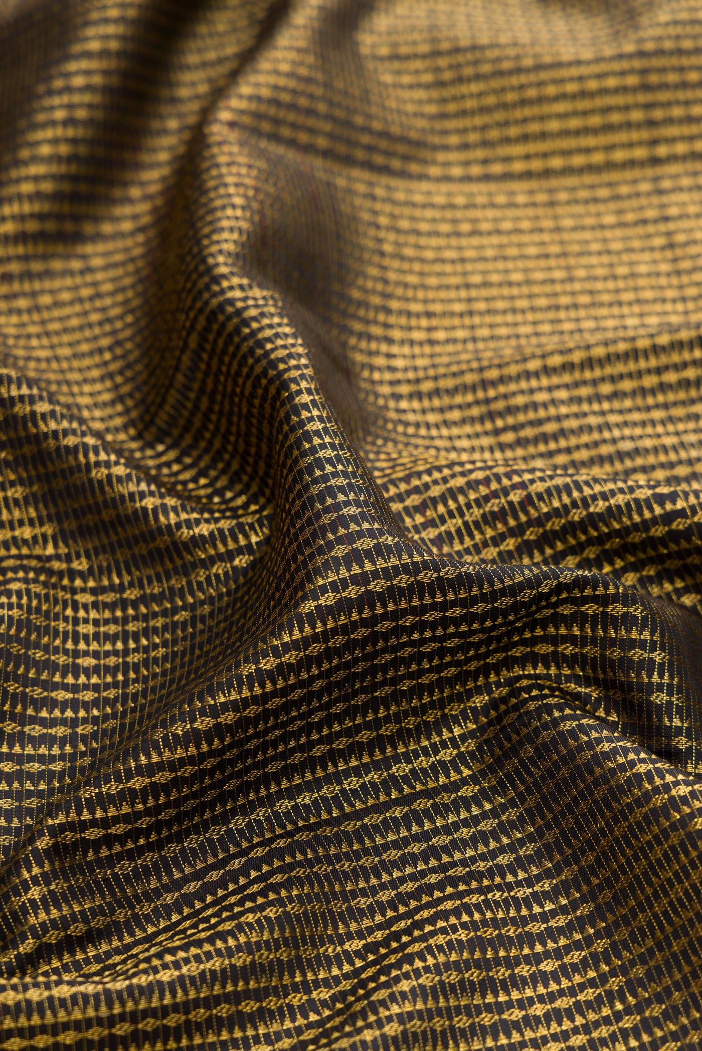 Close up of Black Kanchipuram Silk Saree with Zari Brocade on the body and Zari Border.  displaying folds