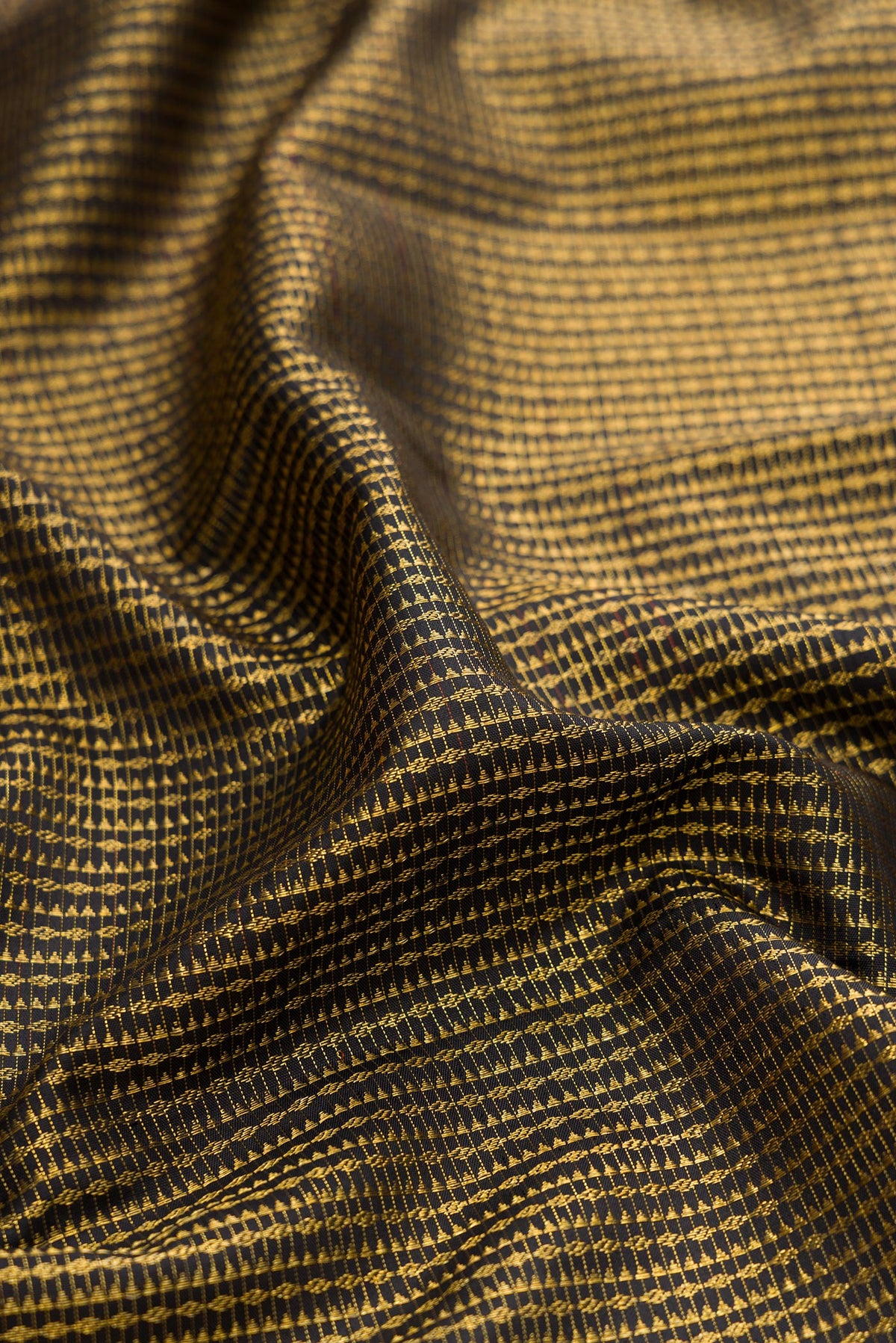 Close up of Black Kanchipuram Silk Saree with Zari Brocade on the body and Zari Border.  displaying folds