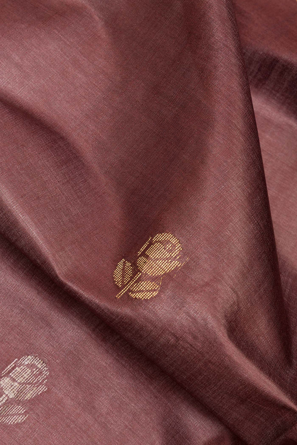 Close up of Pure Silk Brown Dual Tone Tussar Saree with Zari Butta on the body and Zari Border.  displaying folds