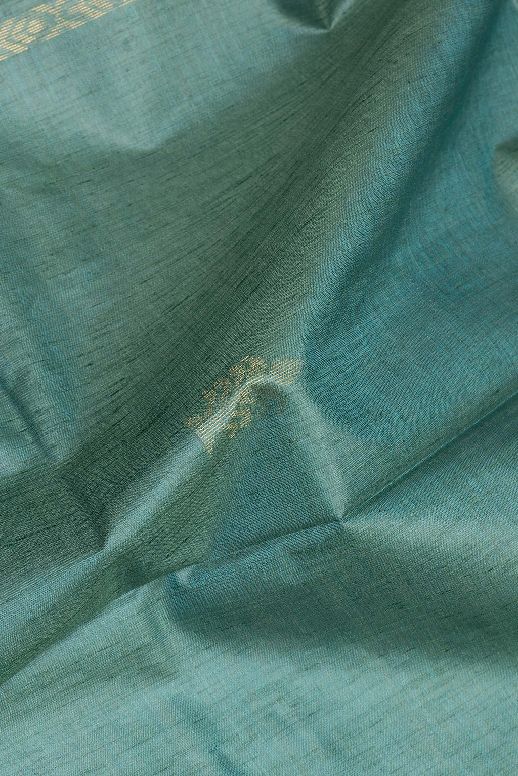 Close up of Pure Silk Green Dual Tone Tussar Saree with Zari Butta on the body and Zari Border.  displaying folds
