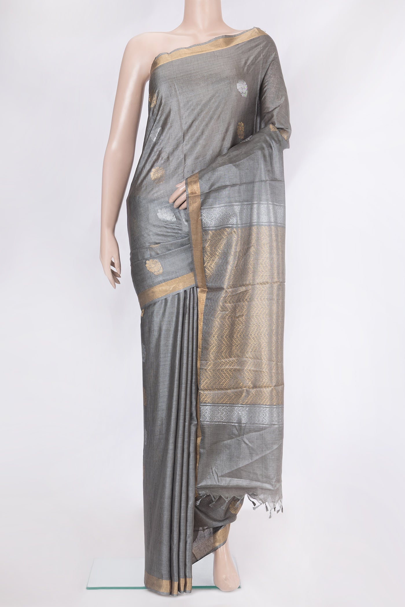 Grey Tussar Silk Saree with Zari Butta on the body and Zari Border.  displayed on a mannequin