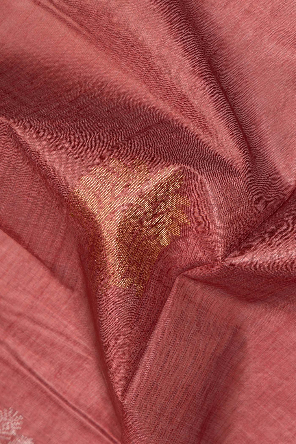 Close up of Pure Silk Rust Dual Tone Tussar Saree with Zari Butta on the body and Zari Border.  displaying folds