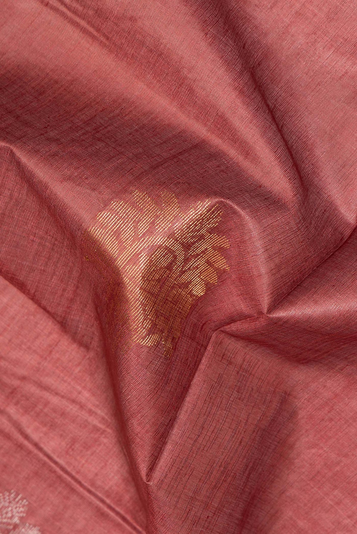 Close up of Pure Silk Rust Dual Tone Tussar Saree with Zari Butta on the body and Zari Border.  displaying folds