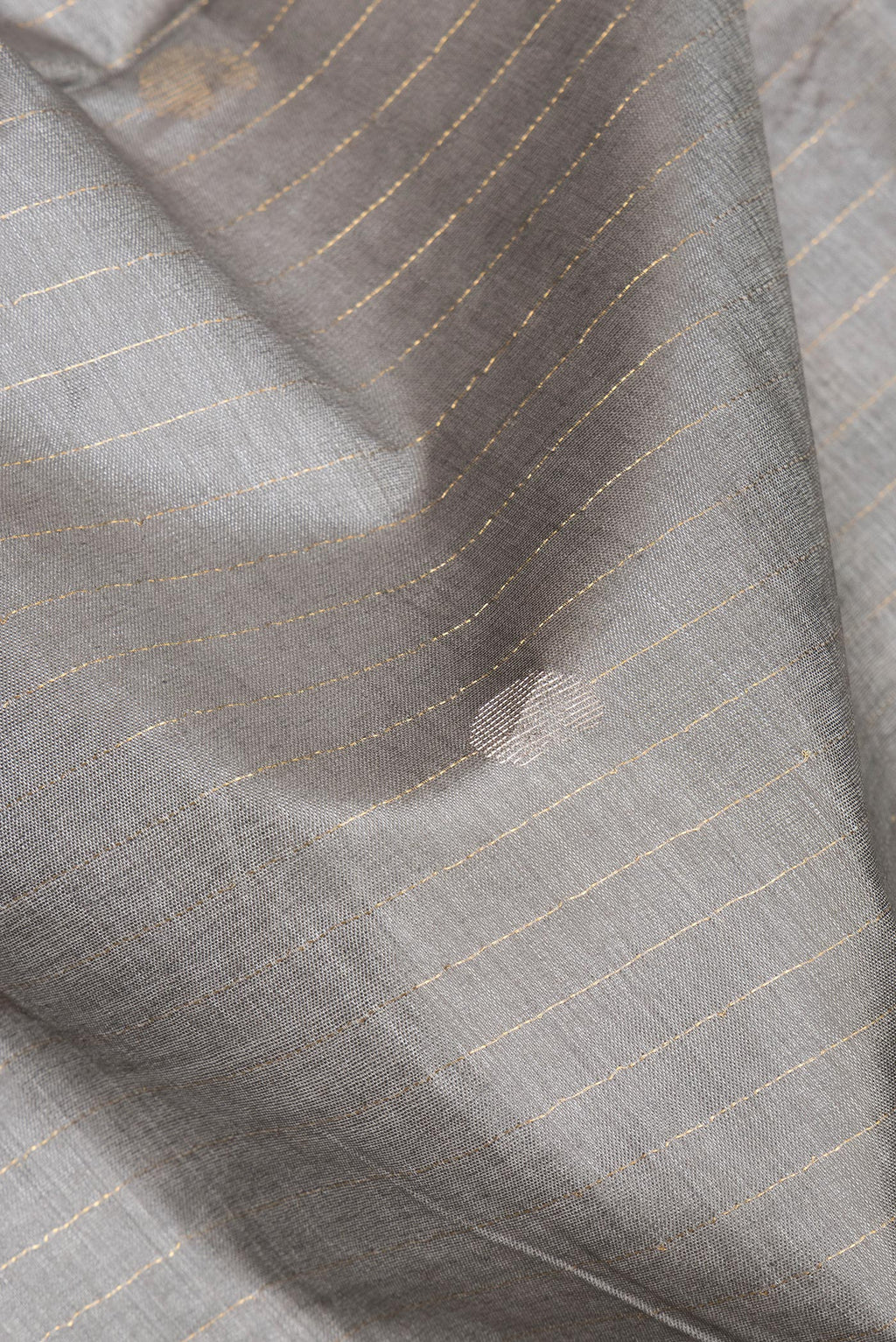 Close up of Pure Silk Grey Dual Tone Tussar Saree with Stripes on the body and Zari Border.  displaying folds