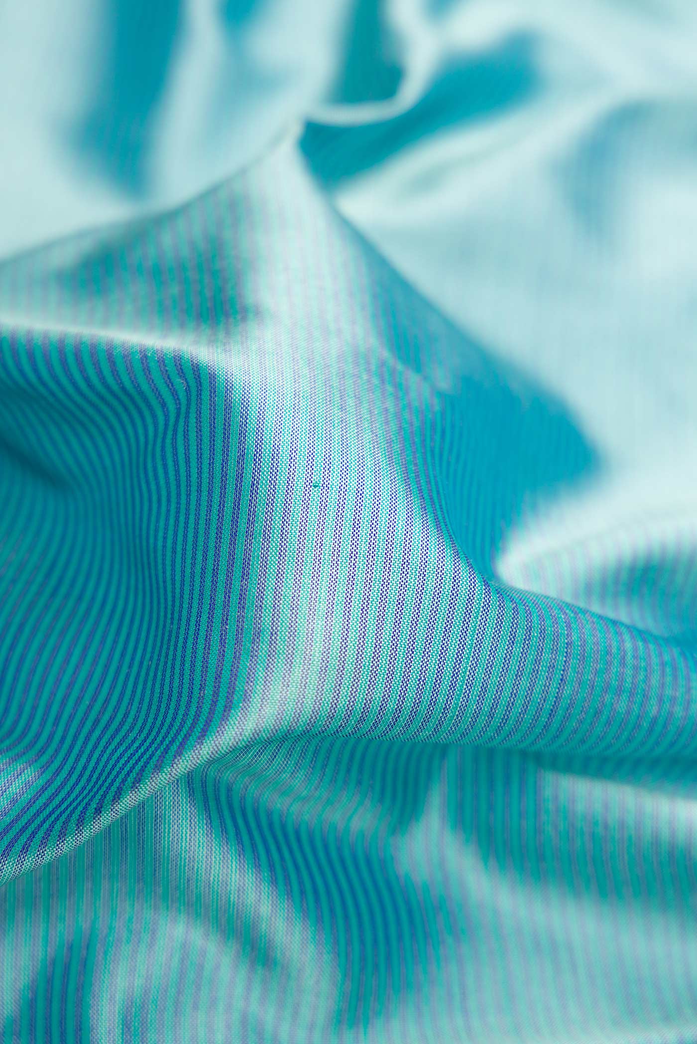 Close up of Maya Blue Dual Tone Maheshwari Silk Saree with Stripes on the body and Zari Border.  displaying folds