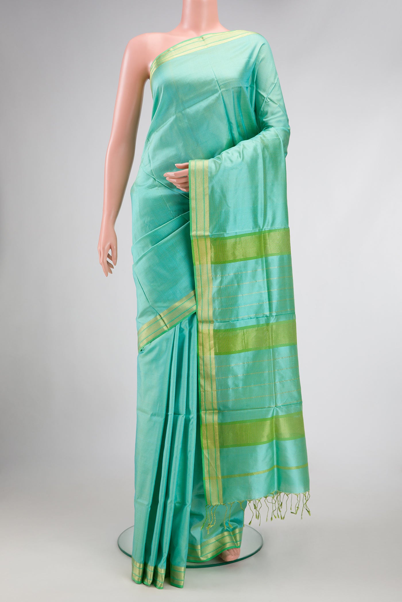 Sea Green Dual Tone Maheshwari Silk Saree with Stripes on the body and Zari Border.  displayed on a mannequin