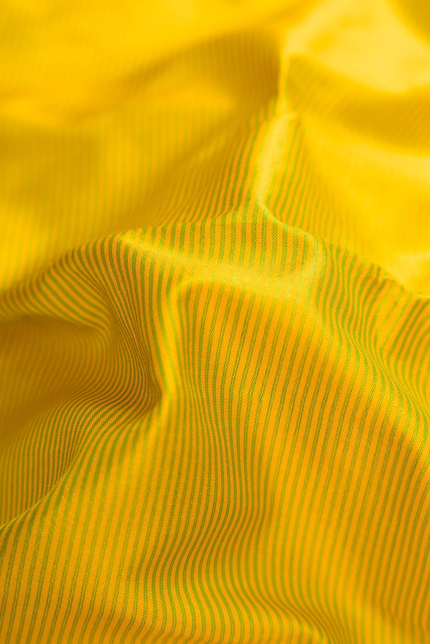 Close up of Lemon Yellow Dual Tone Maheshwari Silk Saree with Stripes on the body and Zari Border.  displaying folds
