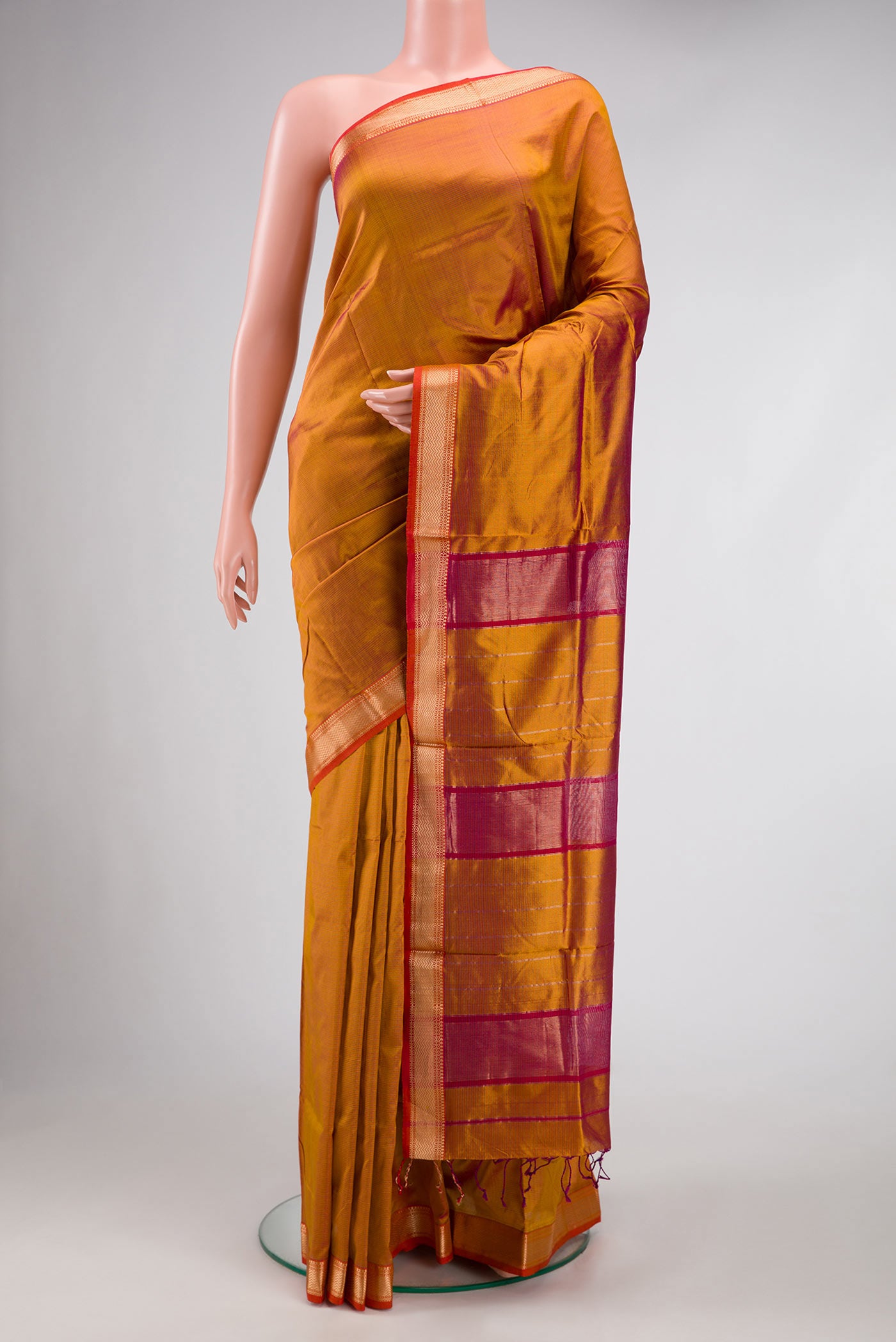 Mustard Dual Tone Maheshwari Silk Saree with Stripes on the body and Zari Border.  displayed on a mannequin