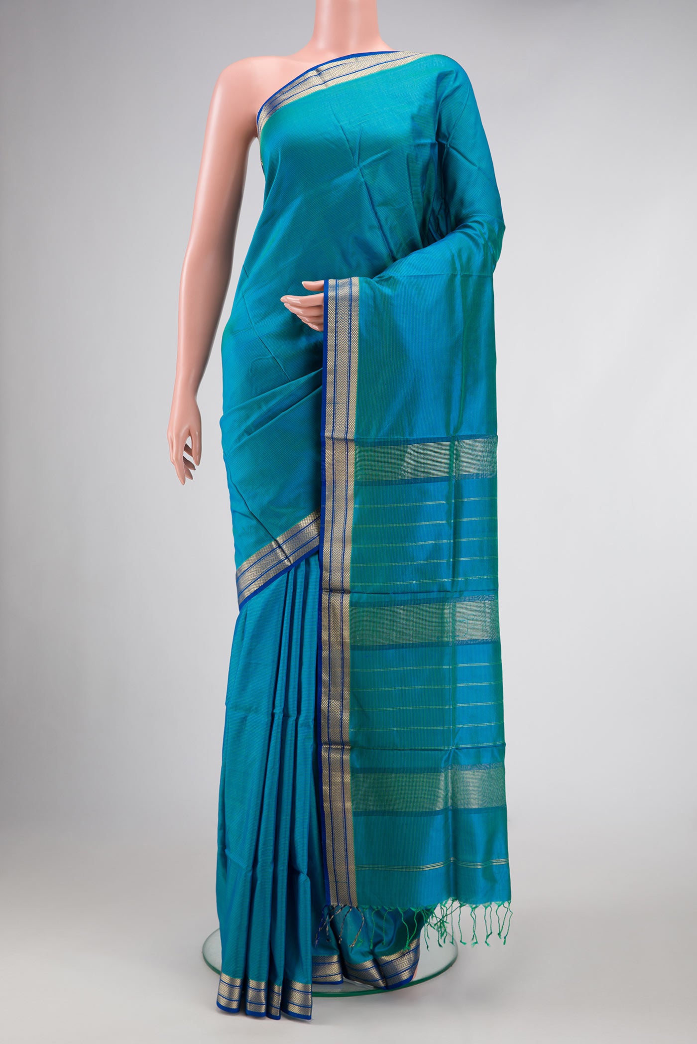 Peacock Blue Dual Tone Maheshwari Silk Saree with Stripes on the body and Zari Border.  displayed on a mannequin