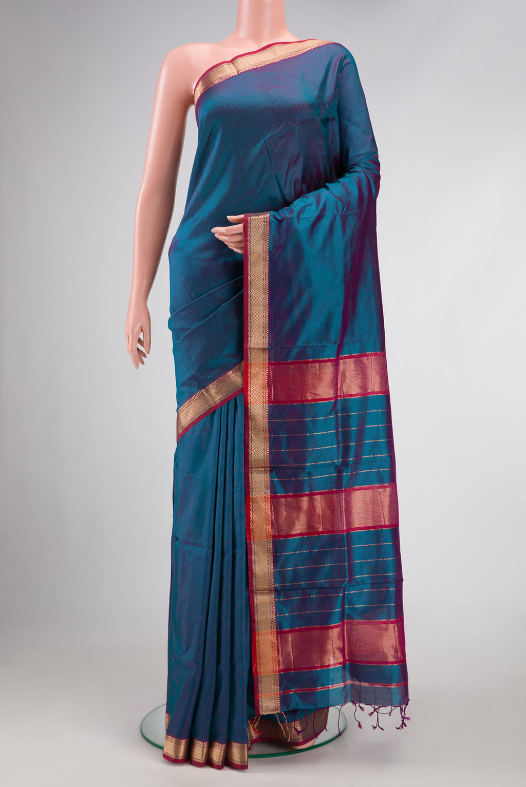 Peacock Blue Dual Tone Maheshwari Silk Saree with Stripes on the body and Zari Border.  displayed on a mannequin