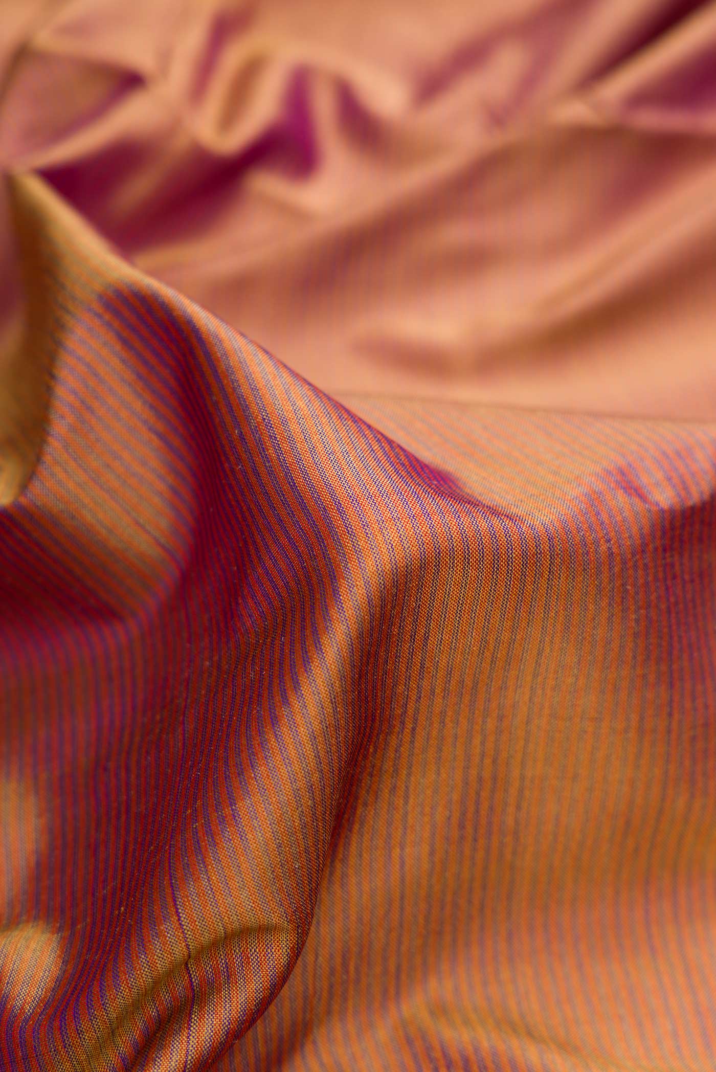 Close up of Brown Dual Tone Maheshwari Silk Saree with Stripes on the body and Zari Border.  displaying folds