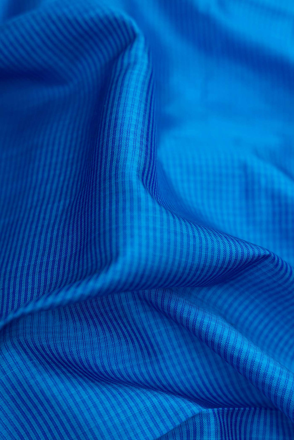 Close up of Royal Blue Dual Tone Maheshwari Silk Saree with Stripes on the body and Zari Border.  displaying folds