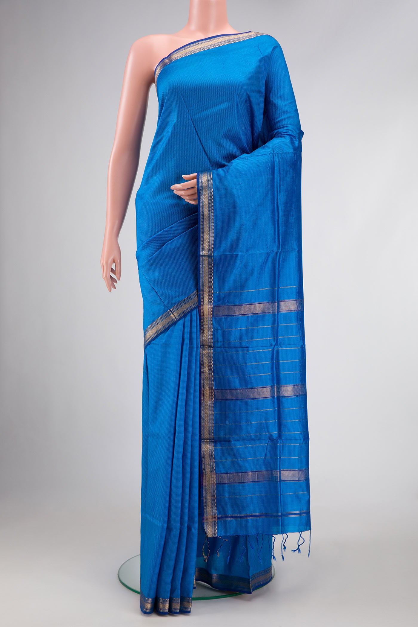 Royal Blue Dual Tone Maheshwari Silk Saree with Stripes on the body and Zari Border.  displayed on a mannequin