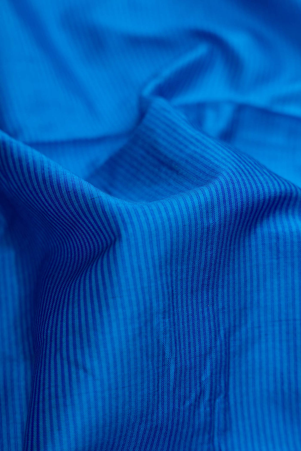 Close up of Royal Blue Dual Tone Maheshwari Silk Saree with Stripes on the body and Zari Border.  displaying folds