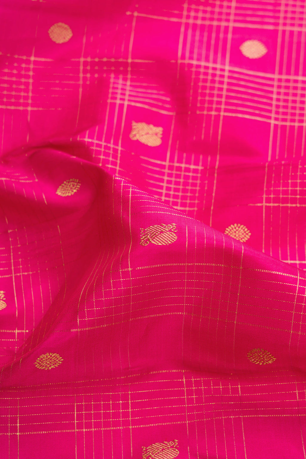 Close up of Dark Pink Dual Tone Kanchipuram Silk Saree with Zari Butta on the body and Zari Border.  displaying folds