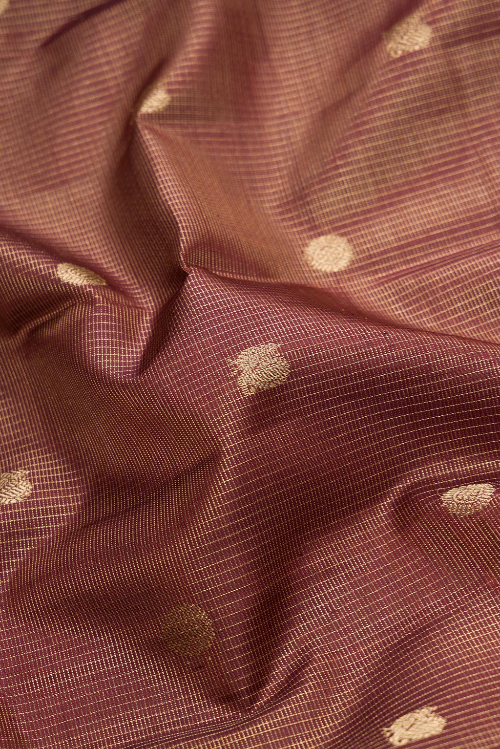 Close up of Pure Silk Pure Zari Maroon Dual Tone Kanchipuram Saree with Checked design on the body and Zari Border.  displaying folds