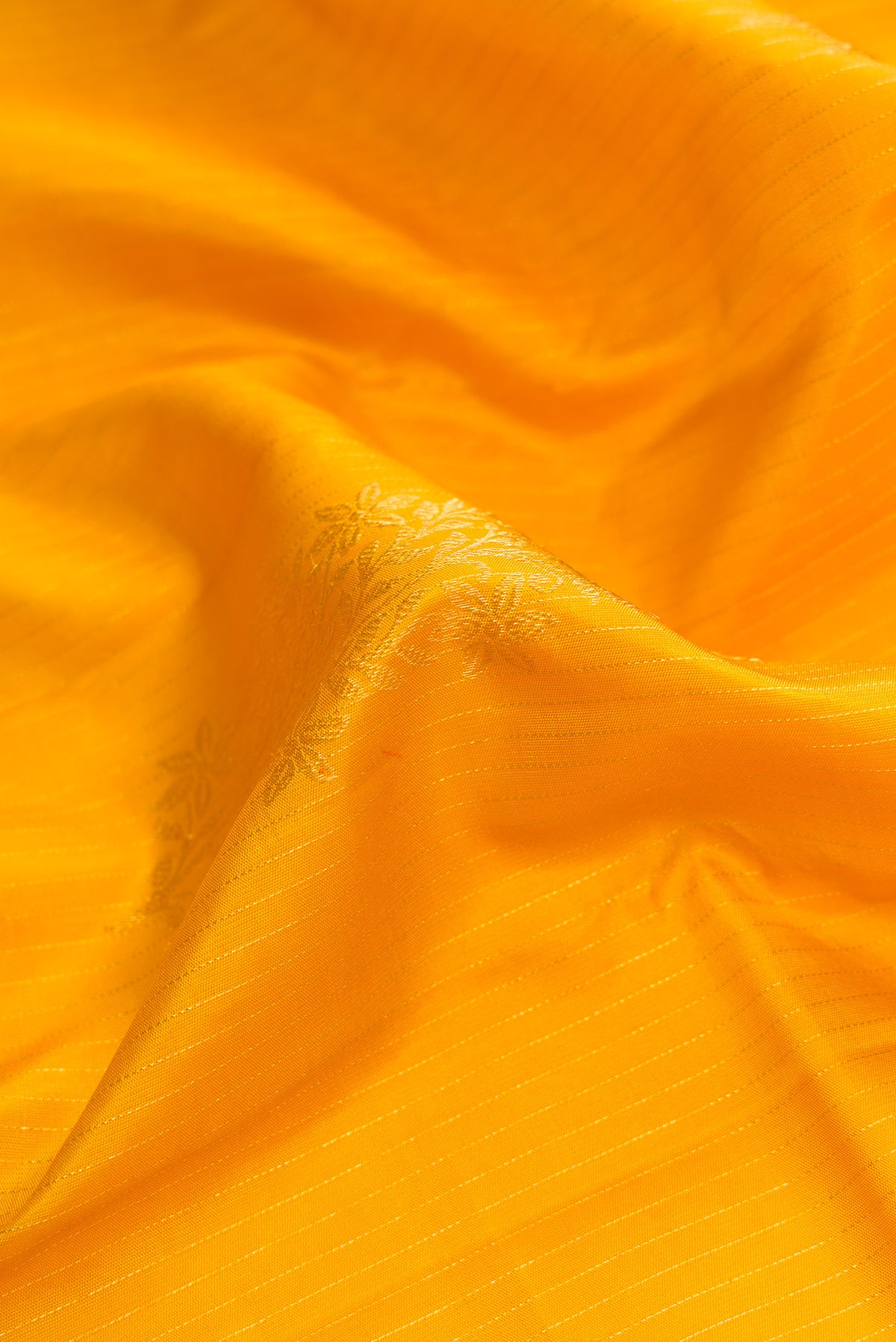 Close up of Yellow Dual Tone Kanjivaram Silk Saree with Stripes on the body and Without Border.  displaying folds