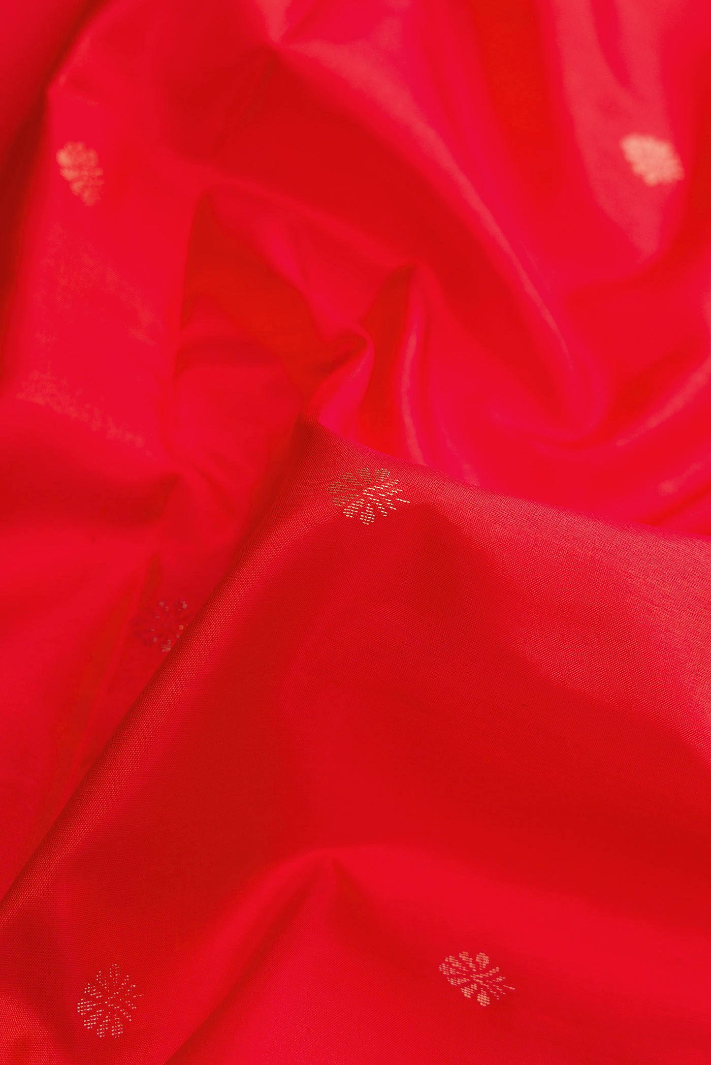 Close up of Red Dual Tone Soft Silk Saree with Zari Butta on the body and Zari Border.  displaying folds