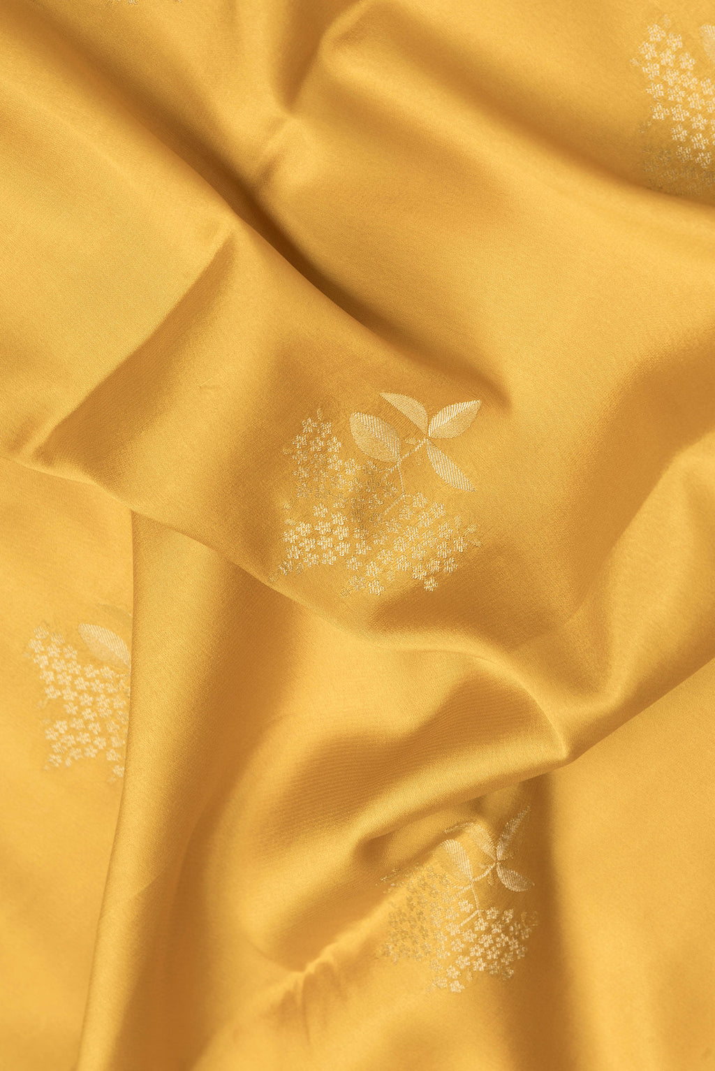 Close up of Mustard Dual Tone Mysore Crepe Saree with Zari Butta on the body and Zari Border.  displaying folds