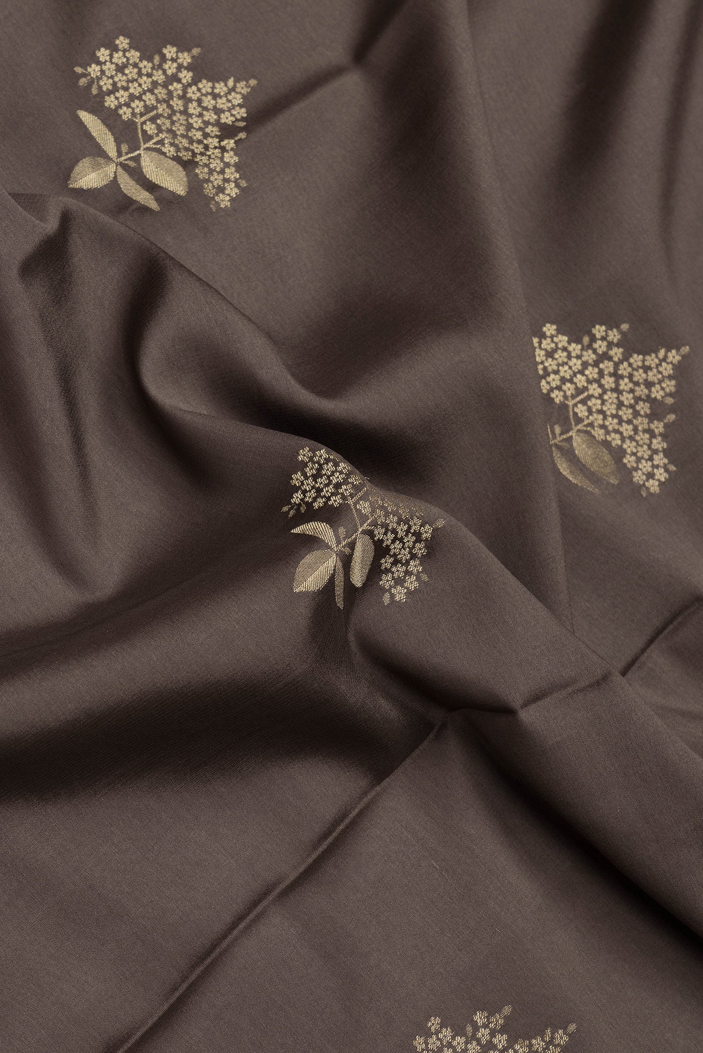 Close up of Brown Dual Tone Mysore Crepe Saree with Zari Butta on the body and Zari Border.  displaying folds