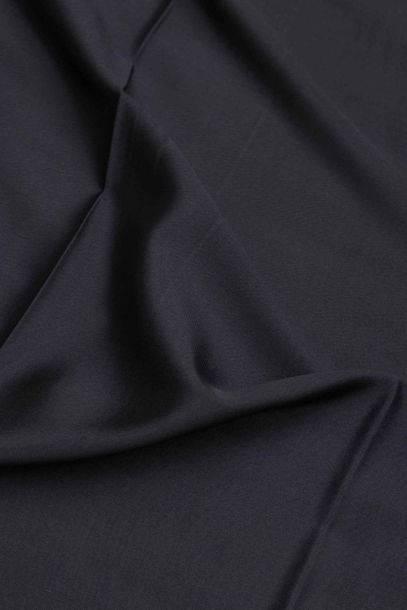 Close up of Black Mysore Silk Saree with Plain Body and Zari Border.  displaying folds