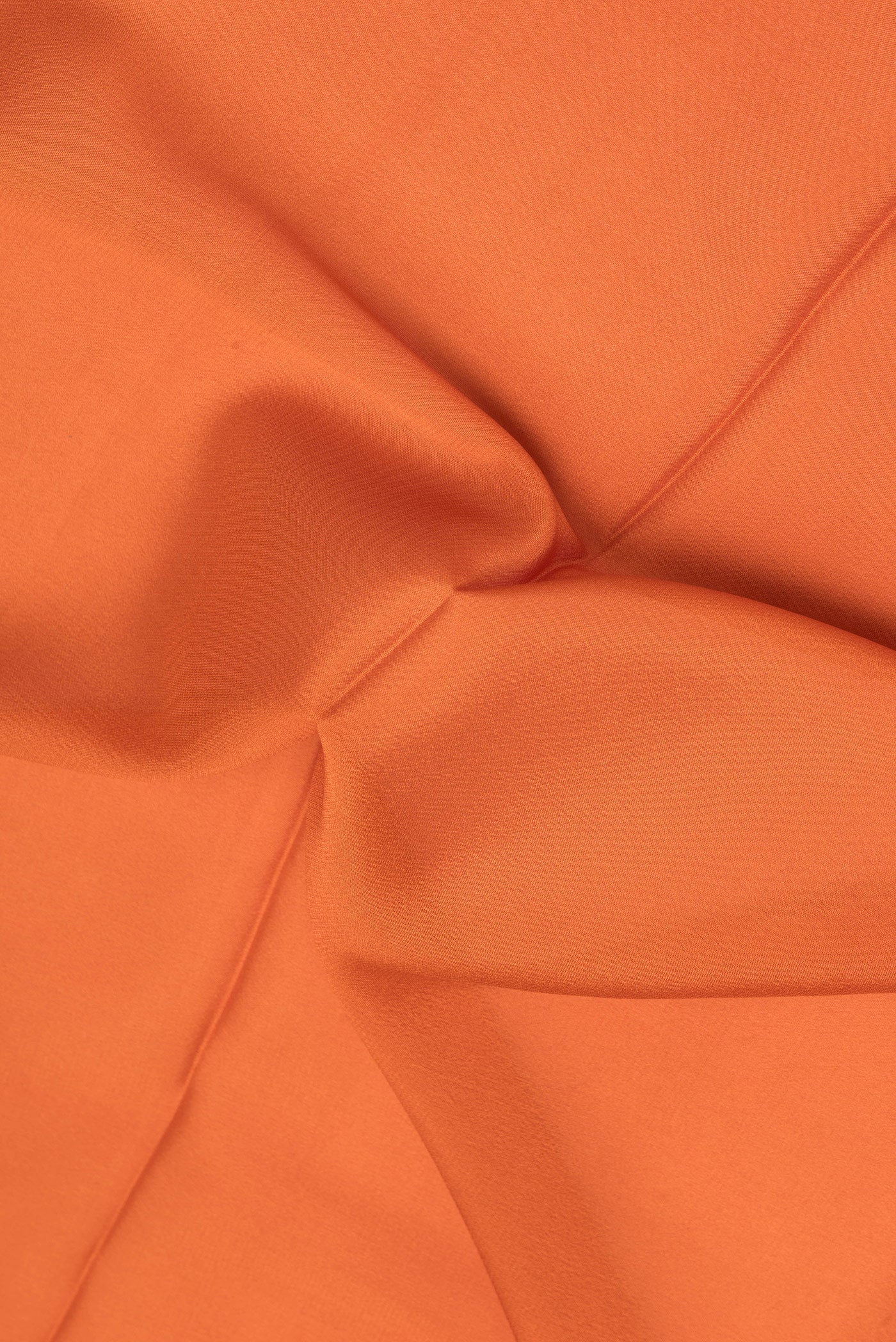 Close up of Brick Orange Mysore Silk Saree with Plain Body and Zari Border.  displaying folds